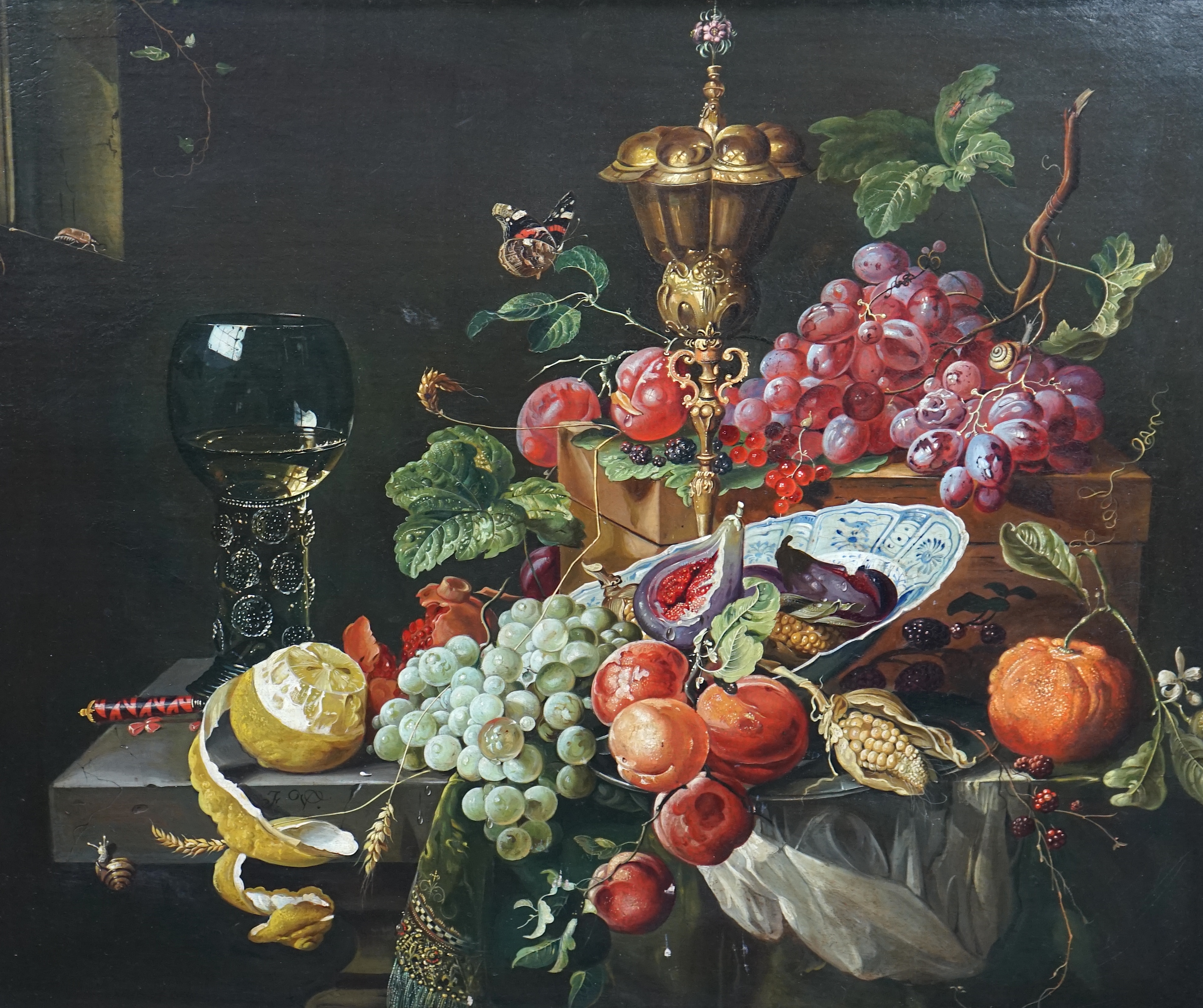 After Abraham Mignon (German, 1640-1679), 17th century style still life of fruit, a rummer and a gilt cup and cover upon a ledge, oil on canvas, 62 x 75cm